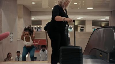 a woman standing next to a luggage bag