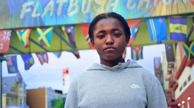 a young girl standing in front of a sign