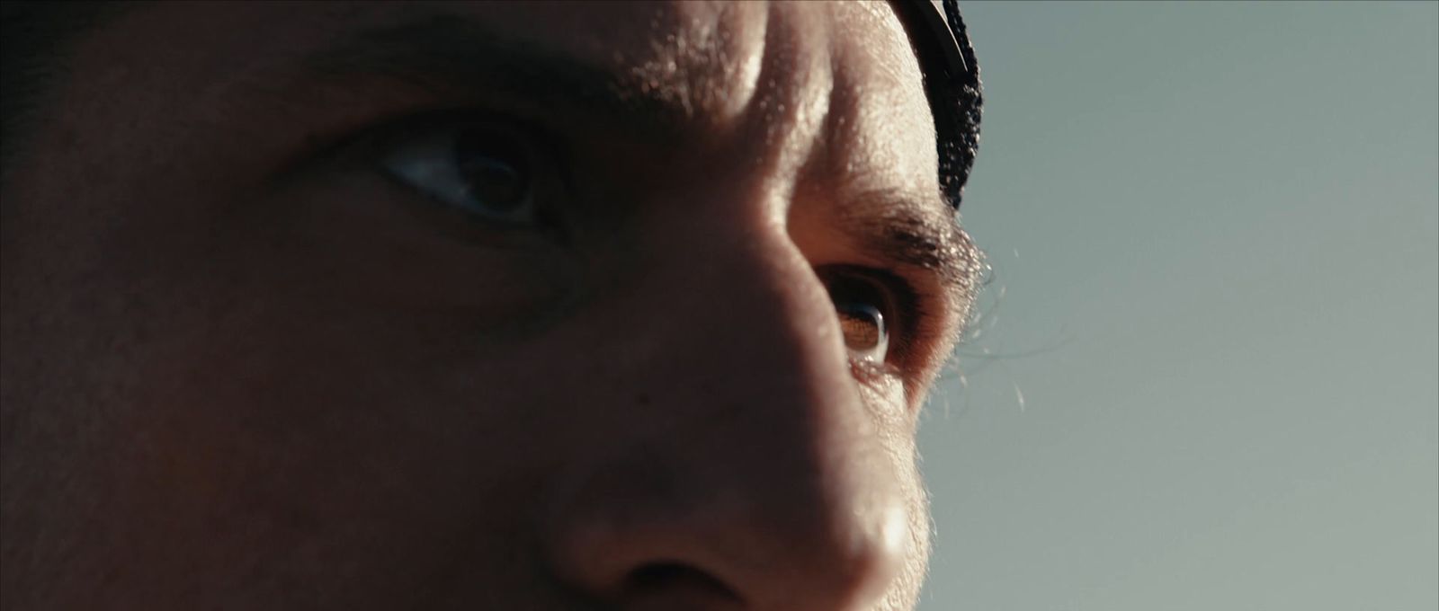 a close up of a man's face with blue eyes