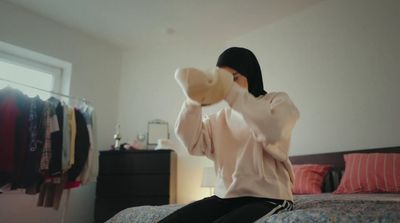 a woman sitting on top of a bed in a bedroom