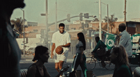 a group of people standing around a man holding a basketball