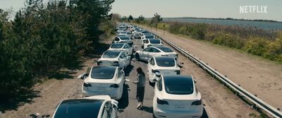 a long line of cars parked on the side of a road