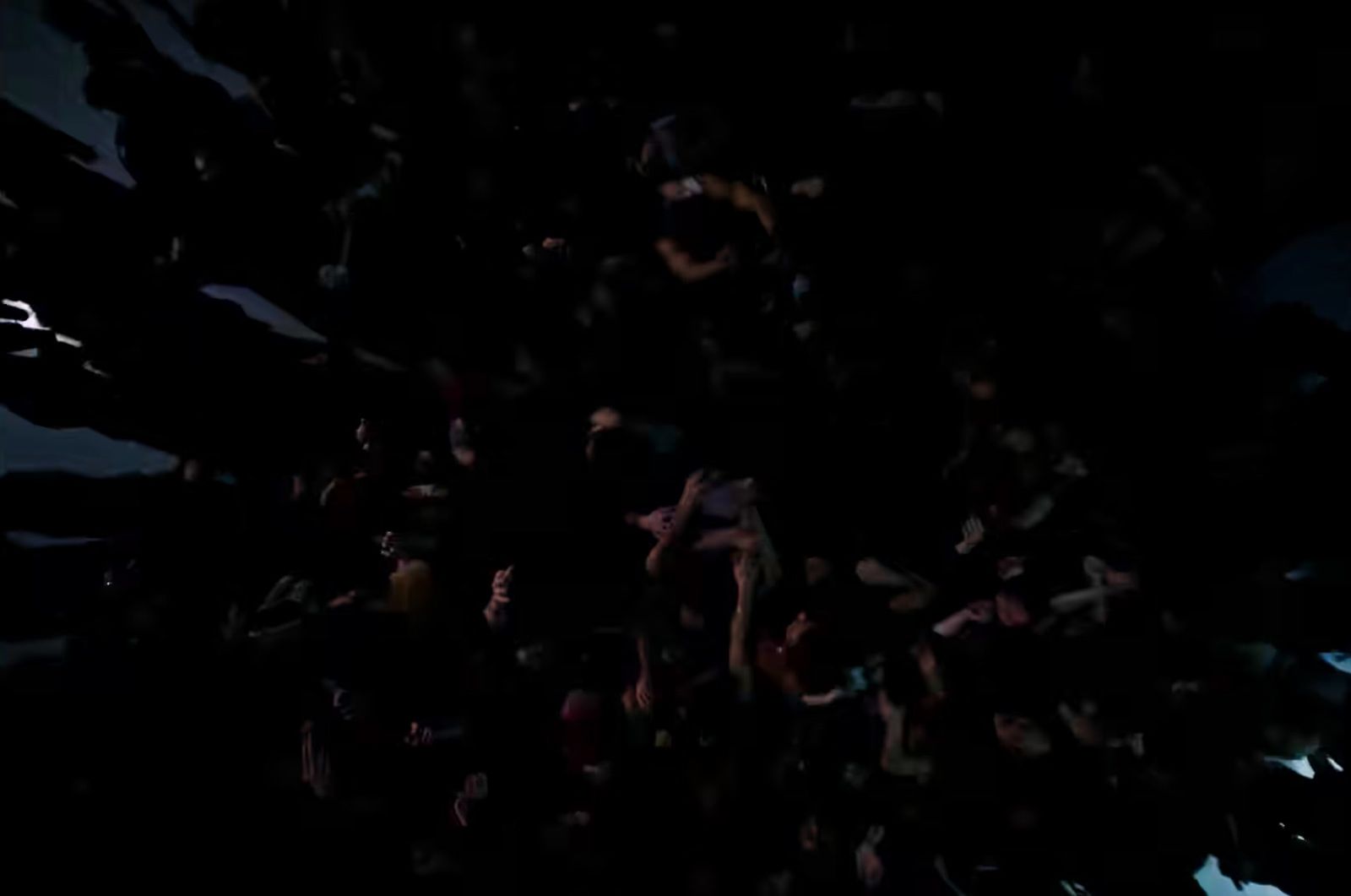 a large group of people standing around in the dark