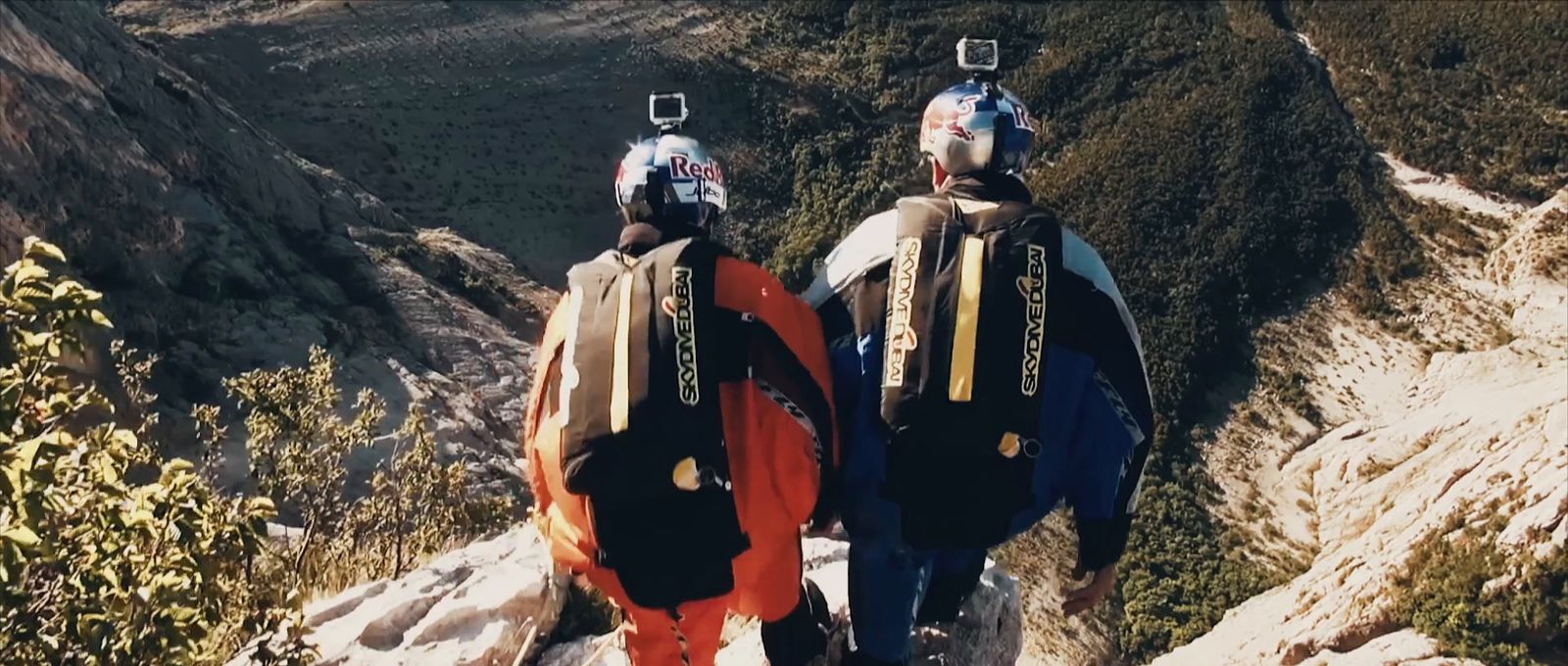 a couple of people standing on top of a mountain