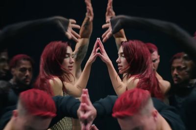 a woman with red hair is surrounded by other people