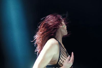 a woman with red hair is performing on stage