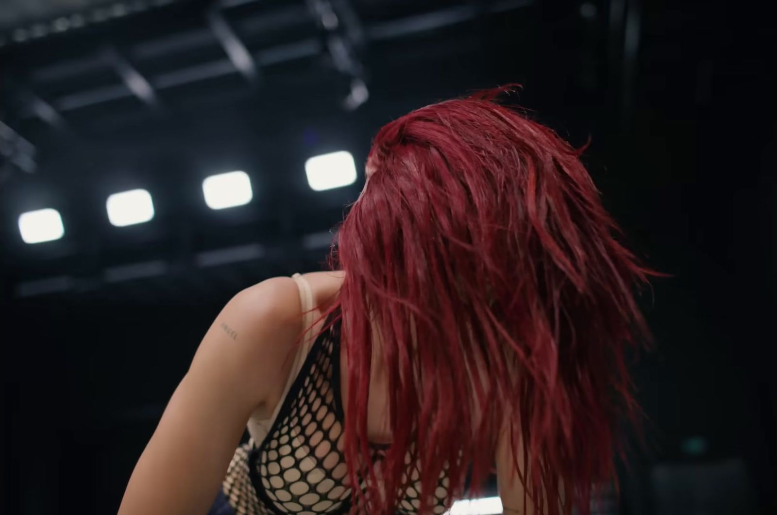 a woman with red hair standing in front of a stage