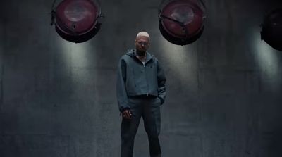 a man standing in front of two red lamps