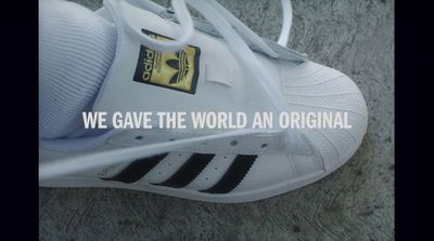 a white adidas sneaker with a black and yellow logo