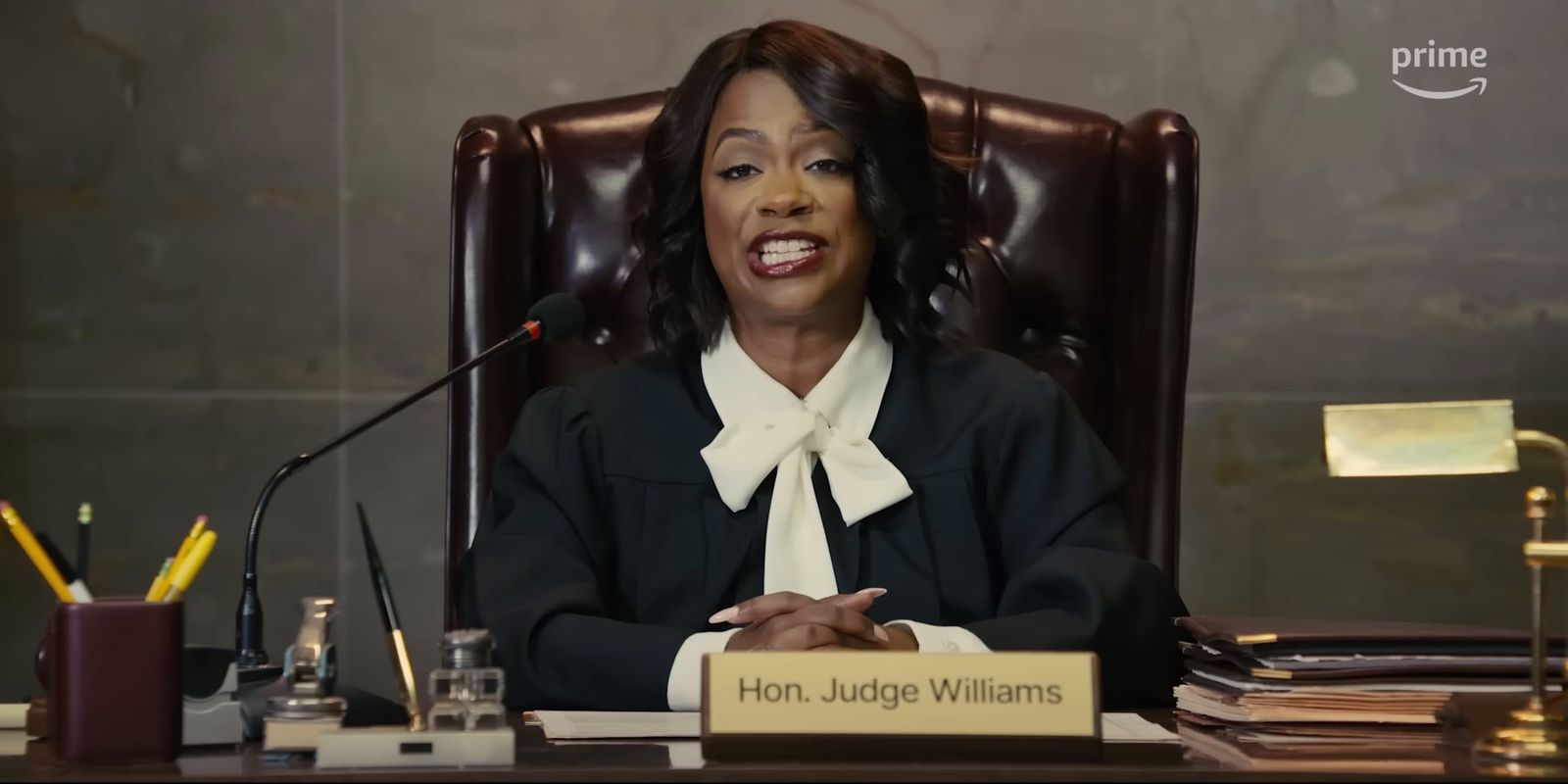 a woman sitting at a desk in front of a microphone