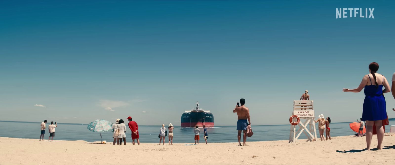 a group of people standing on top of a sandy beach