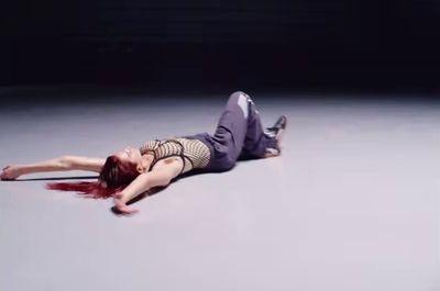 a woman with red hair laying on the ground