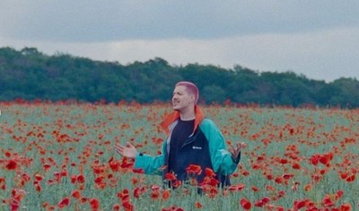 a man standing in a field of red flowers