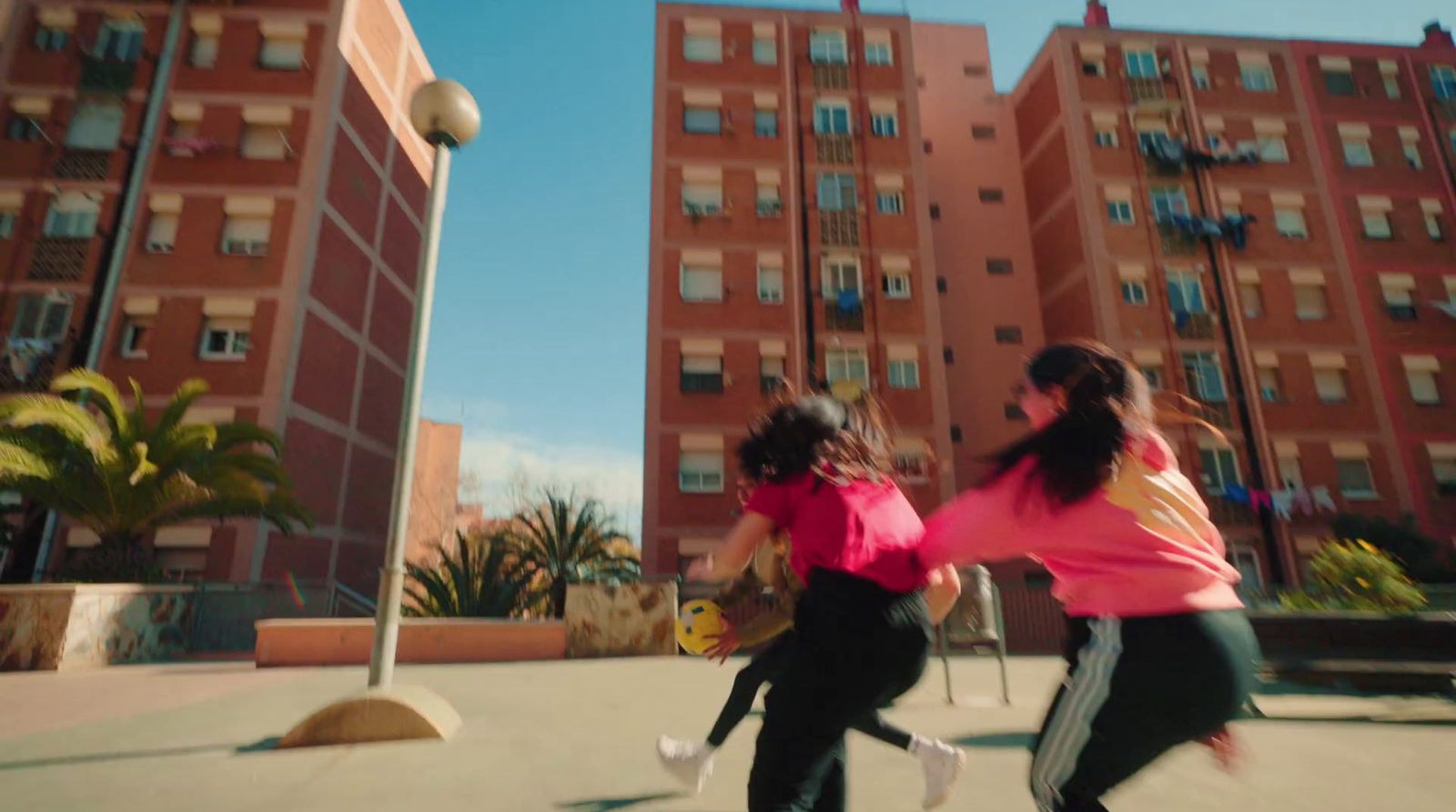 two girls are running in front of a building