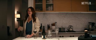 a woman standing in a kitchen next to a counter