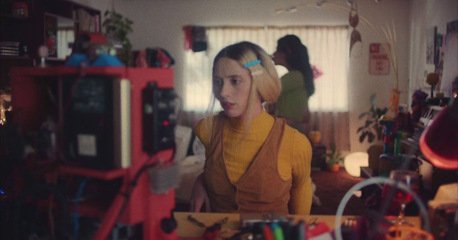 a woman standing in a room with a bunch of clutter