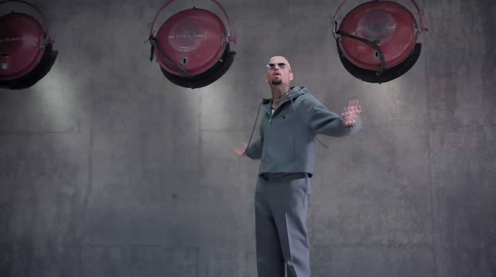 a man standing in front of three red lights