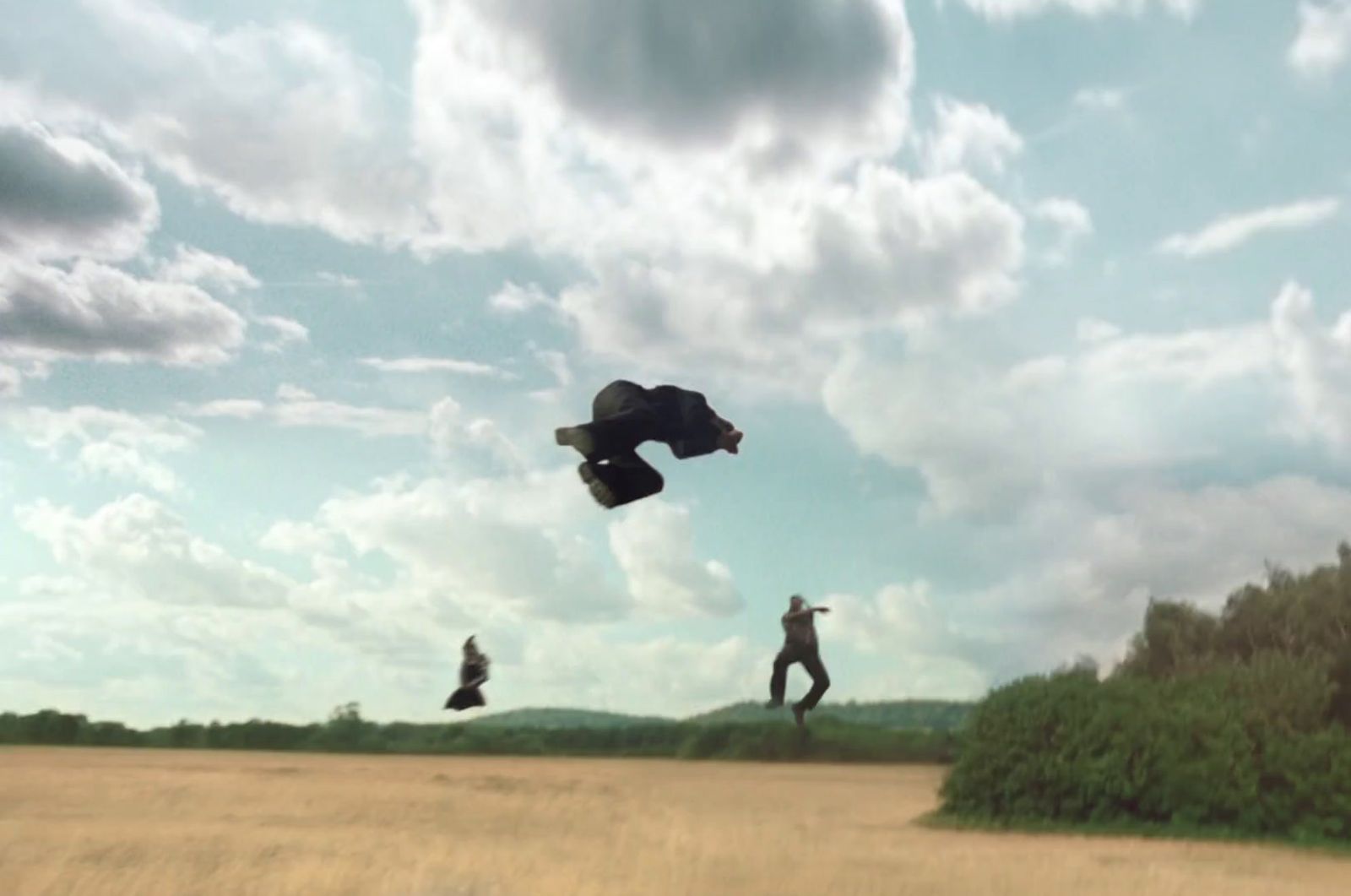 two people are flying a kite in a field