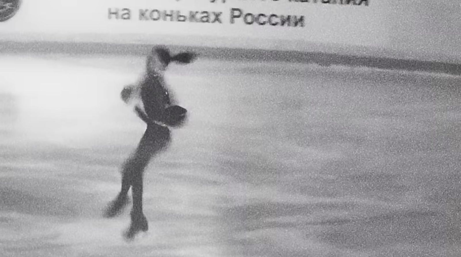 a woman skating on an ice rink in a black and white photo