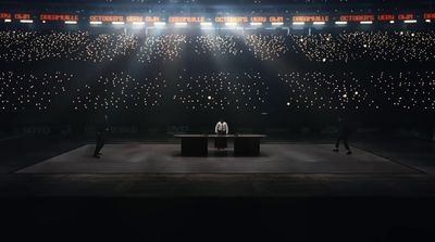 two people standing on a stage in front of a spotlight