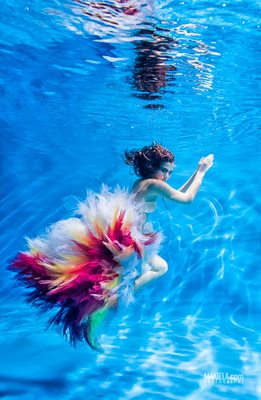 a woman in a colorful dress swimming in a pool