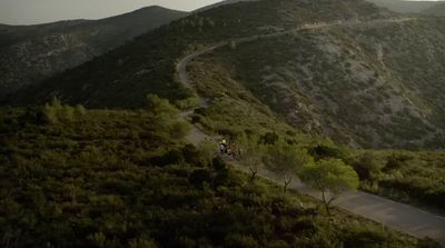 a couple of people riding bikes down a road