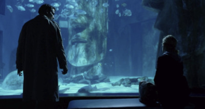 a man and a woman standing in front of an aquarium