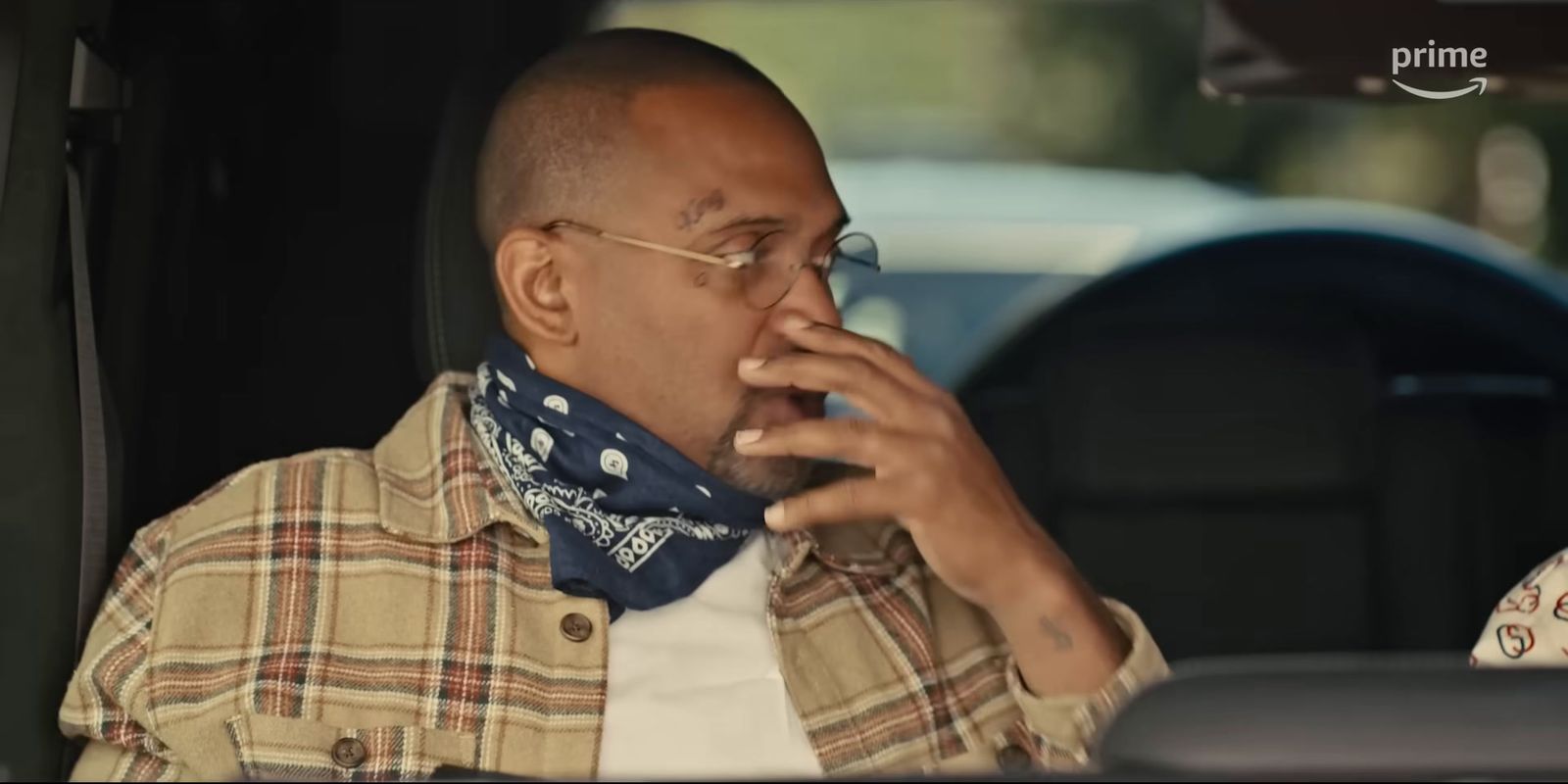 a man sitting in a car talking on a cell phone