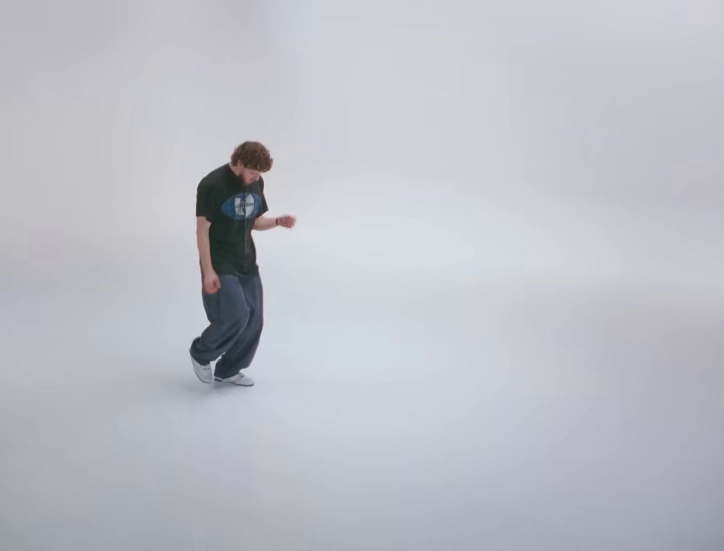 a man in a black shirt is standing in a white room