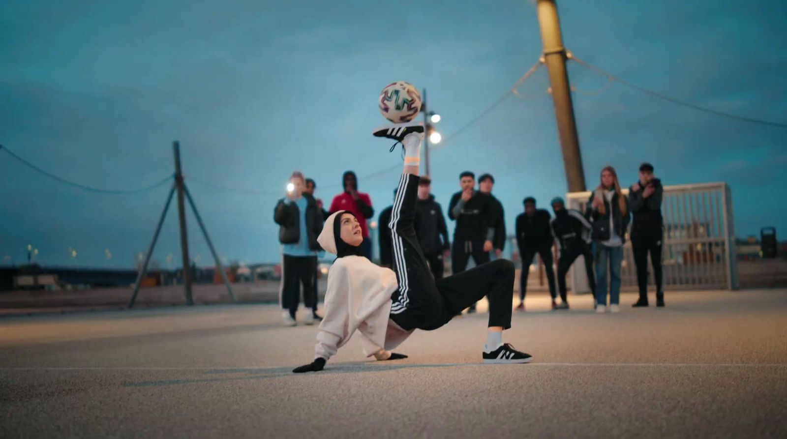 a young man holding a soccer ball up in the air