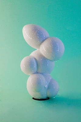 a white sculpture sitting on top of a green surface