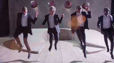 a group of men in suits jumping in the air