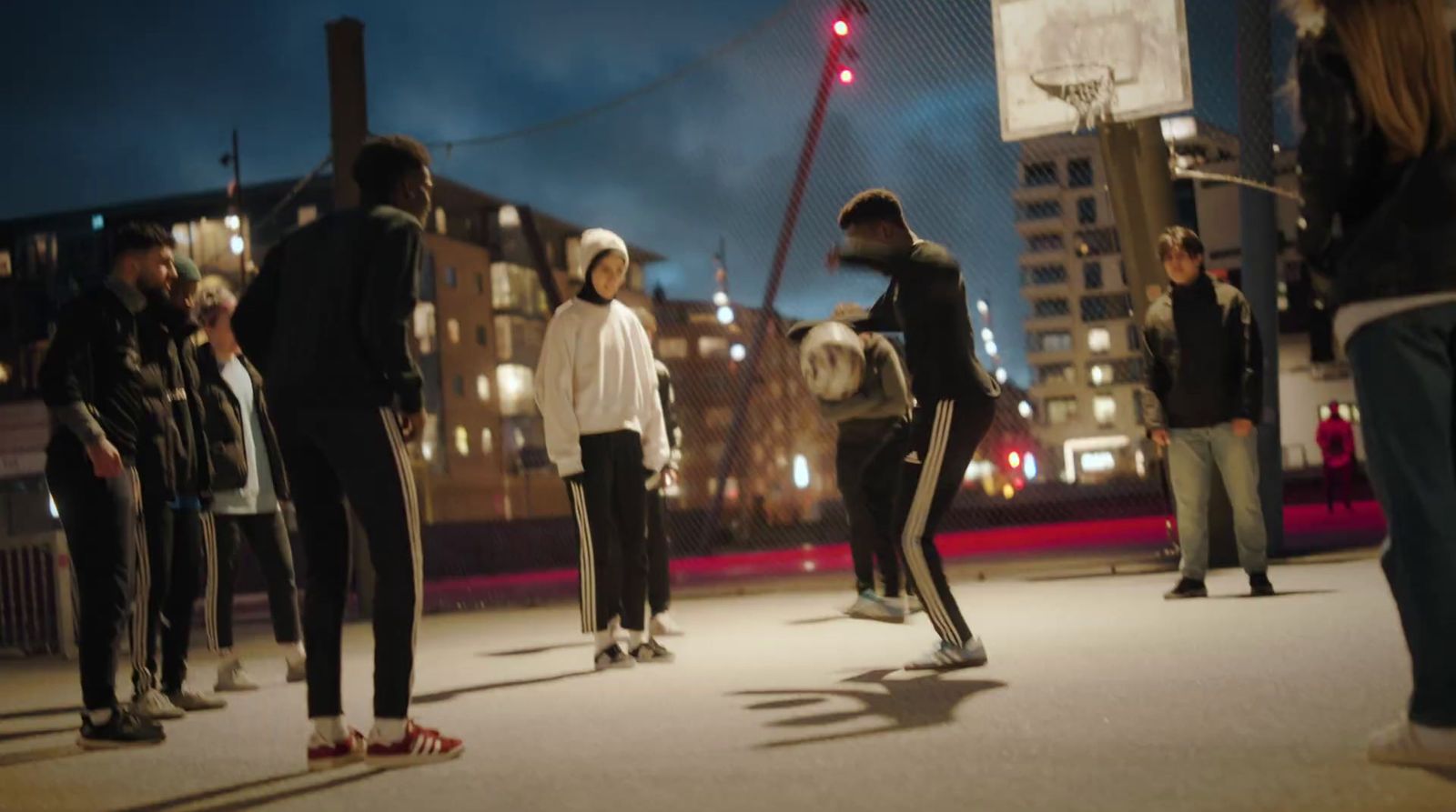 a group of people standing around a basketball court