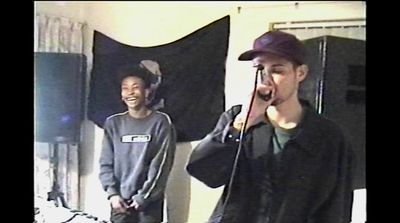 a man standing next to another man holding a microphone