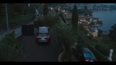 a car driving down a road next to a body of water