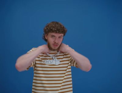 a man in a striped shirt holding his hands to his ears