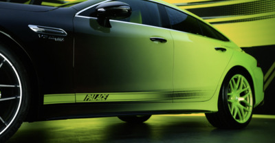 a green car parked in front of a yellow wall