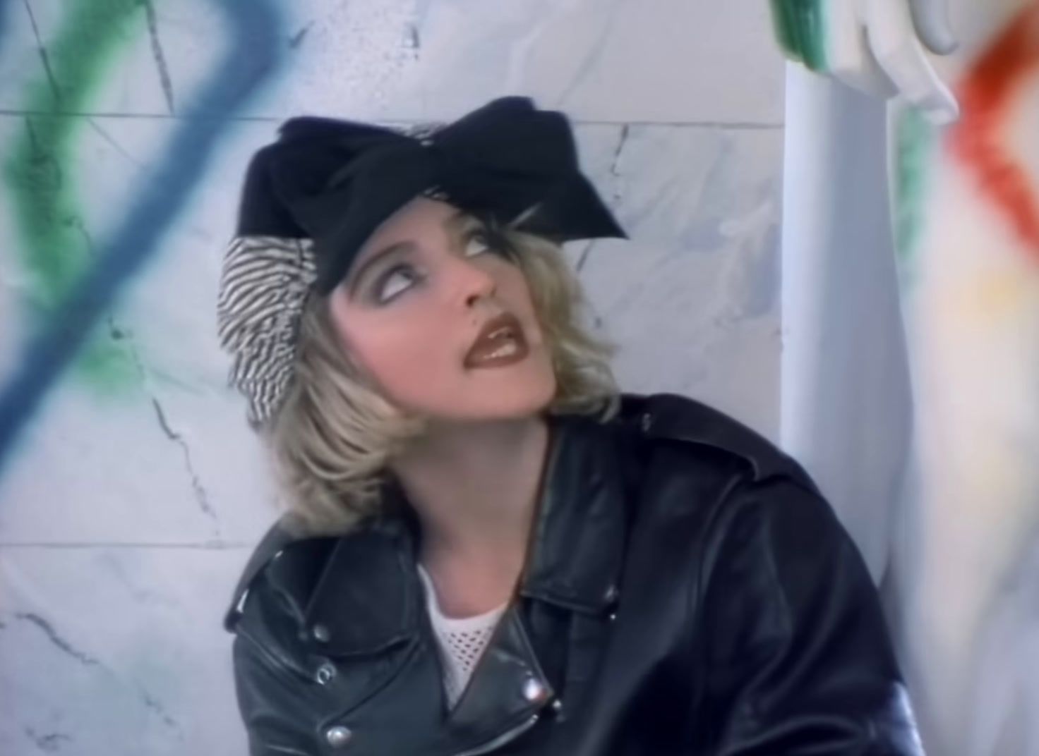 a woman wearing a black hat and leather jacket