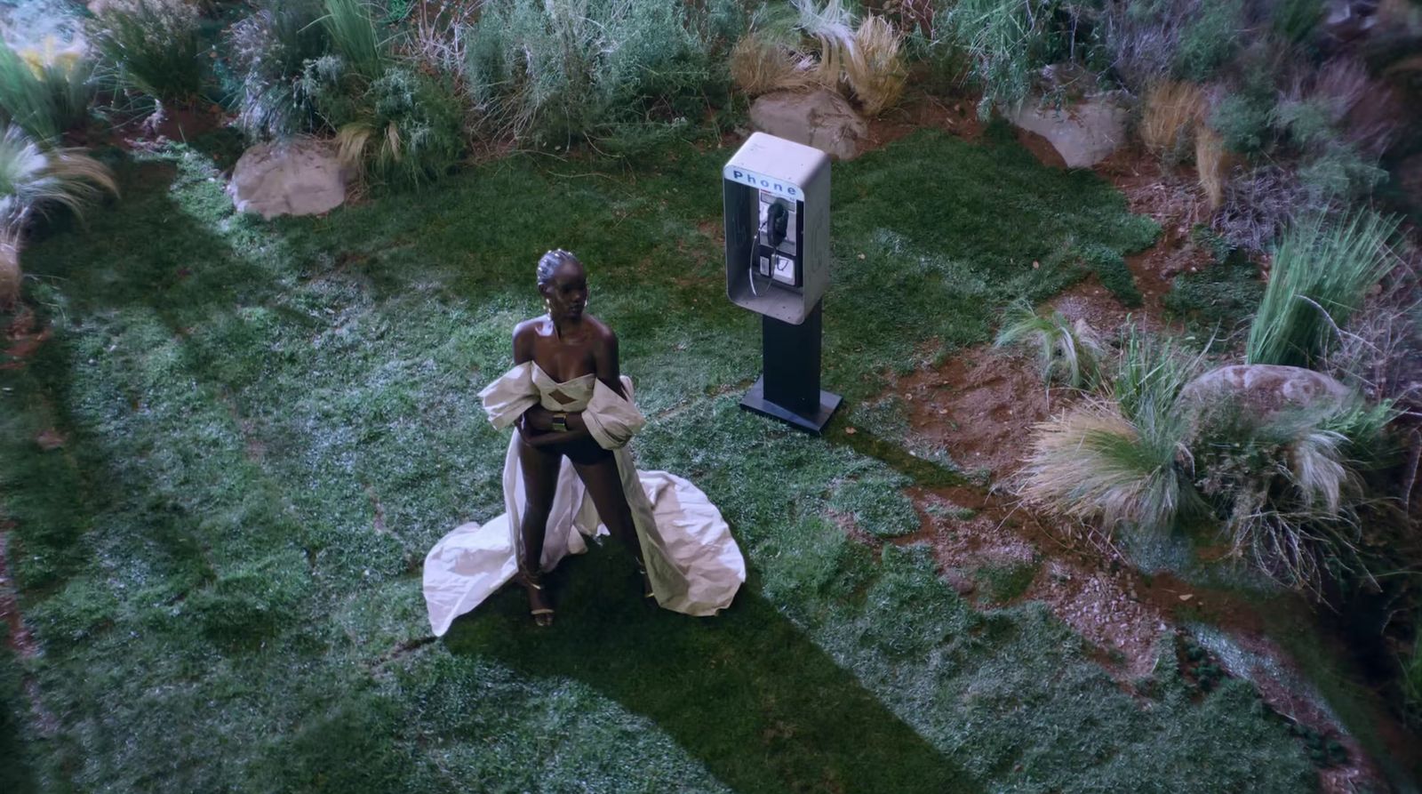 a woman in a white dress standing in a field