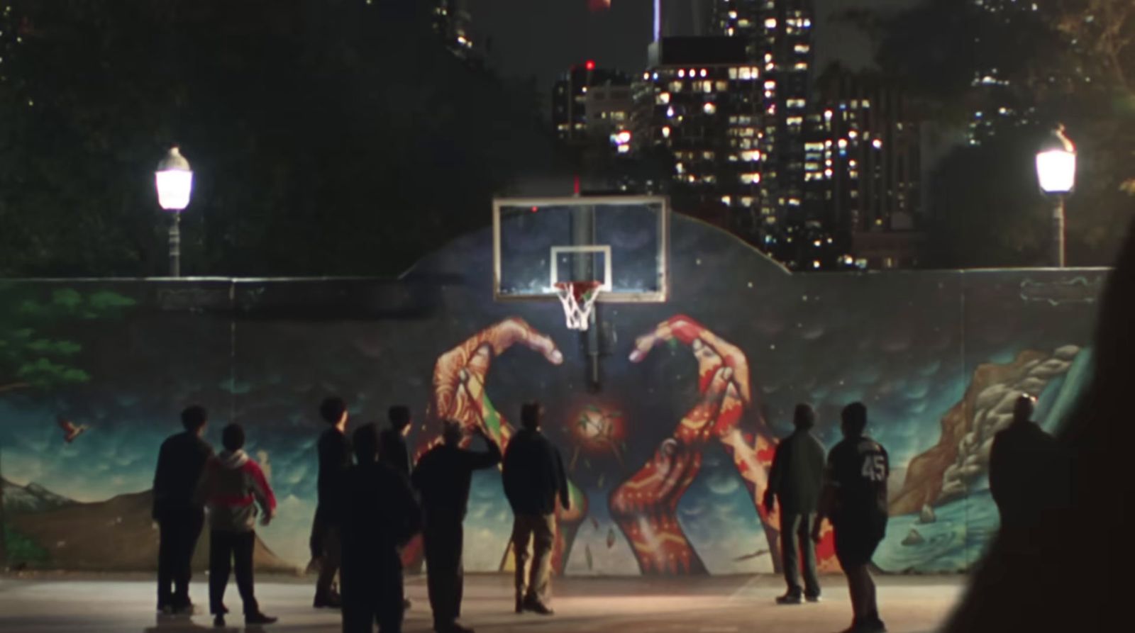 a group of people standing around a basketball court