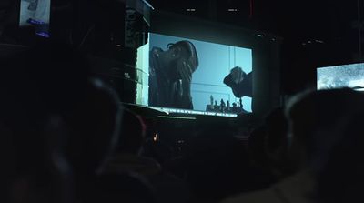 a group of people watching a movie on a large screen