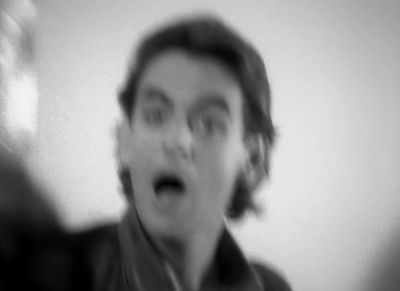 a blurry photo of a man making a surprised face