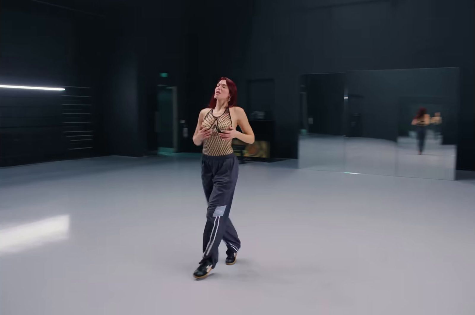 a woman is dancing in a dark room