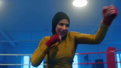 a woman in a boxing ring wearing a yellow outfit