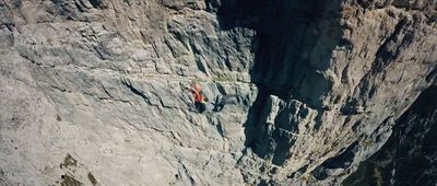 a man climbing up the side of a mountain