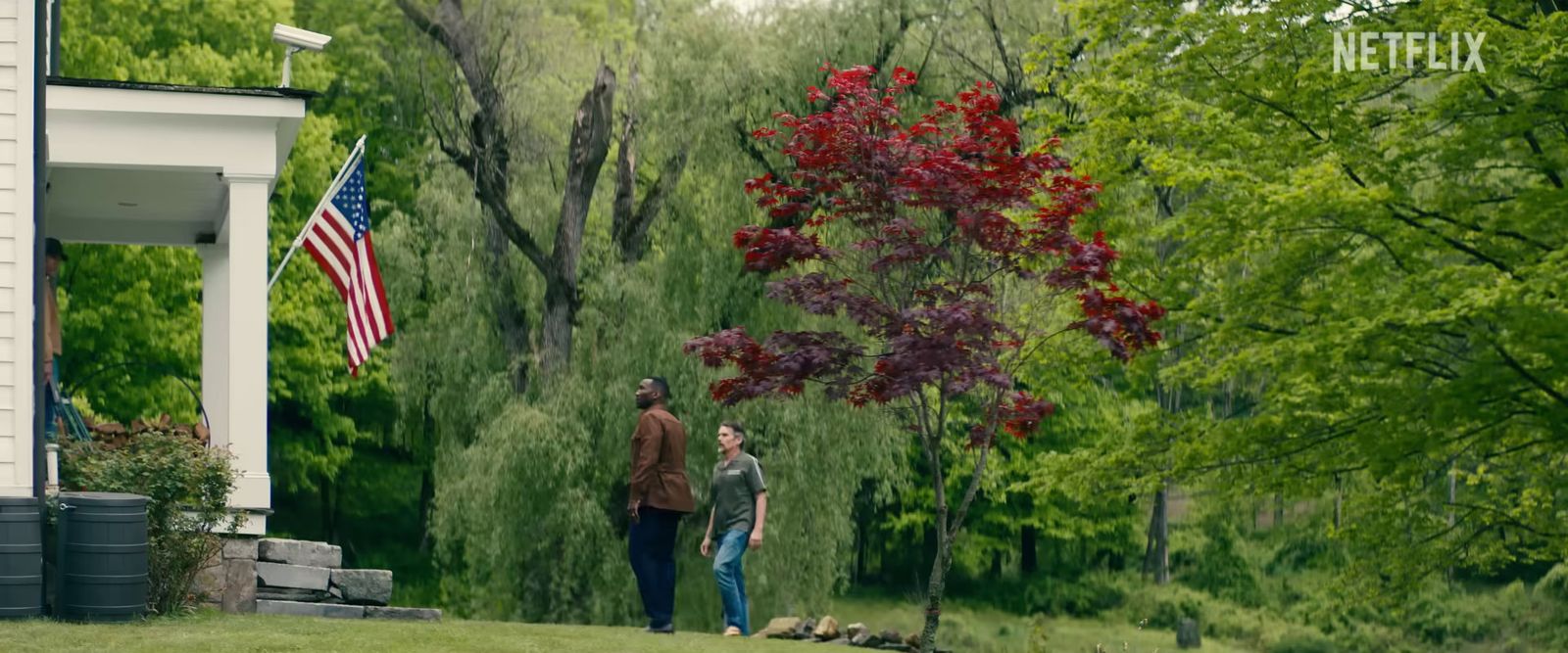 a man and a woman standing in front of a house