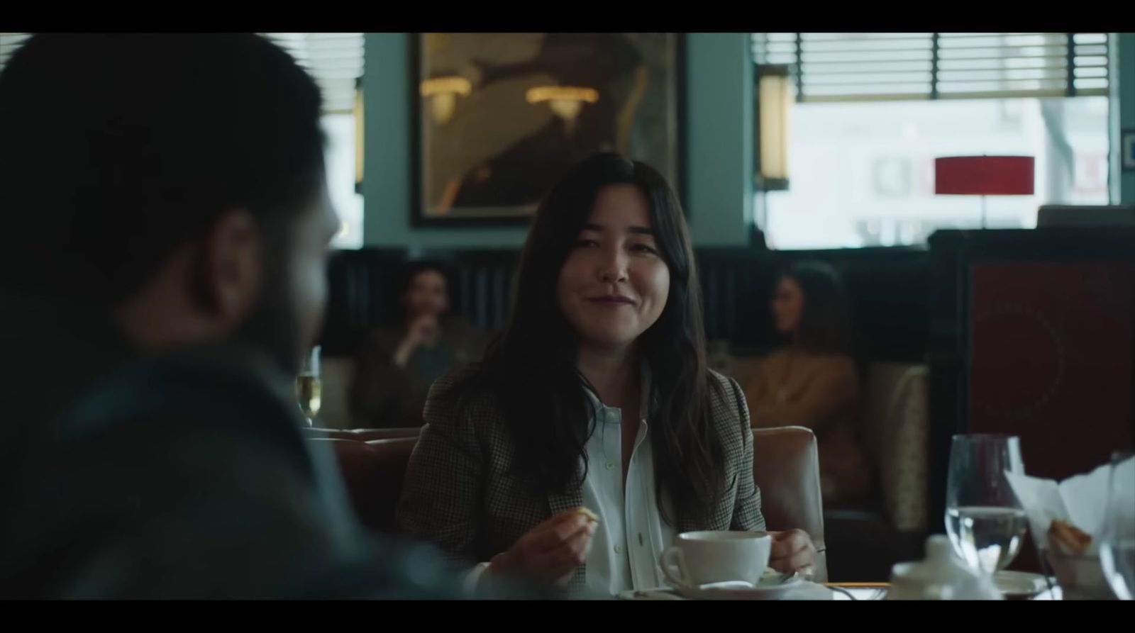 a woman sitting at a table with a cup of coffee