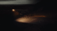 a man is playing basketball on a court at night