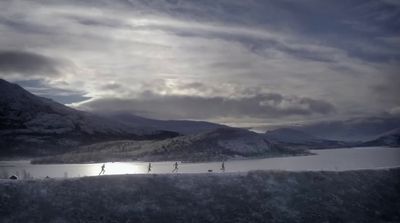 a group of people walking across a snow covered field