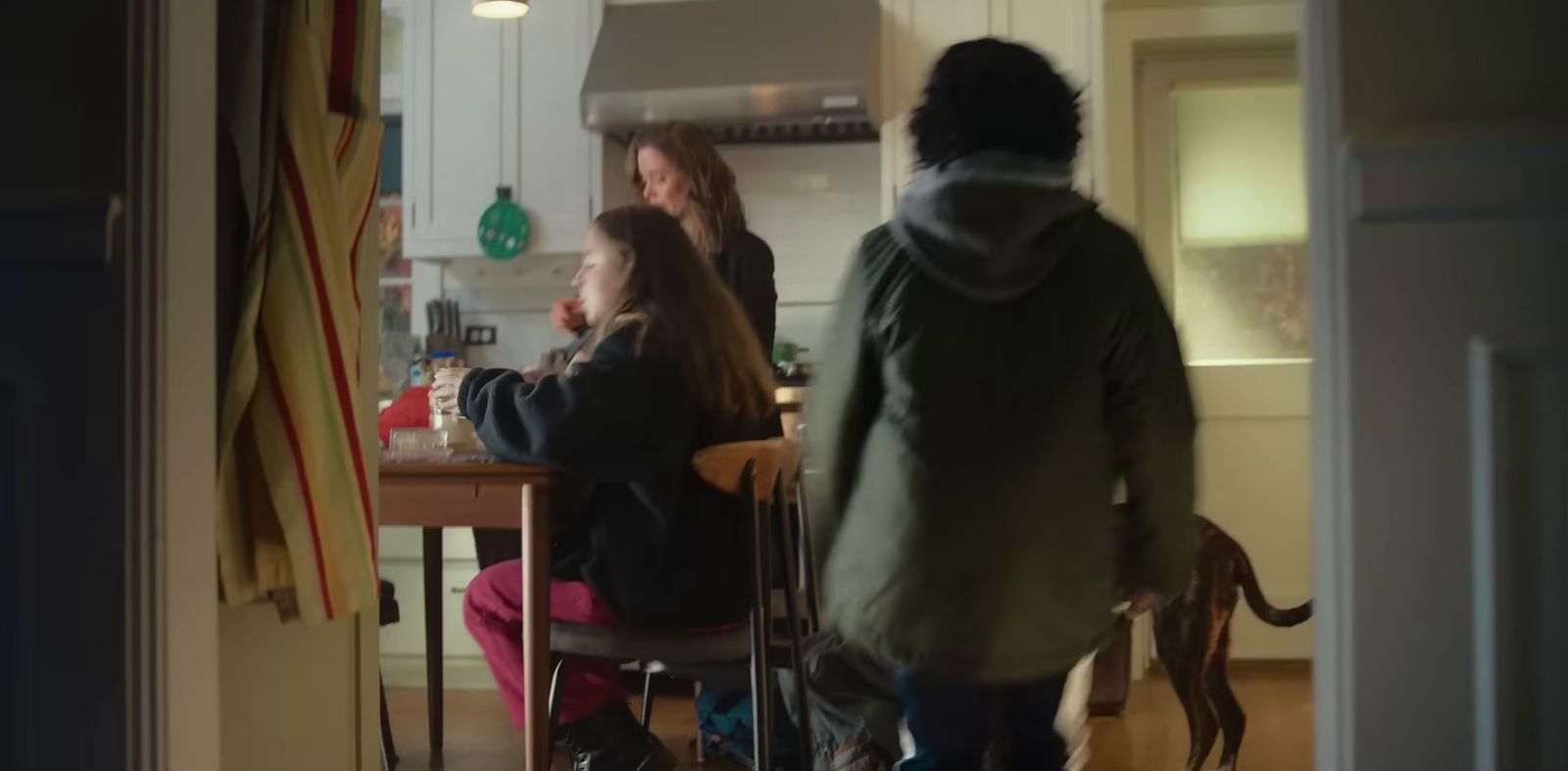 a group of people standing around a kitchen table